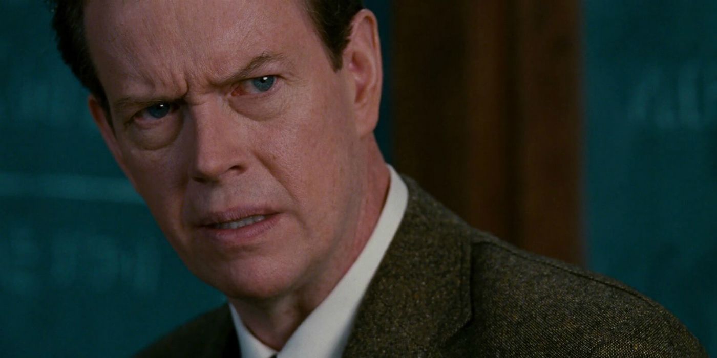 Dylan Baker as Dr. Curt Connors stares with furrowed brows slightly off camera.