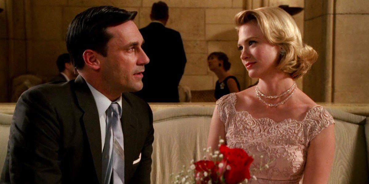 Don Draper and Betty Draper sitting on couch in Mad Men