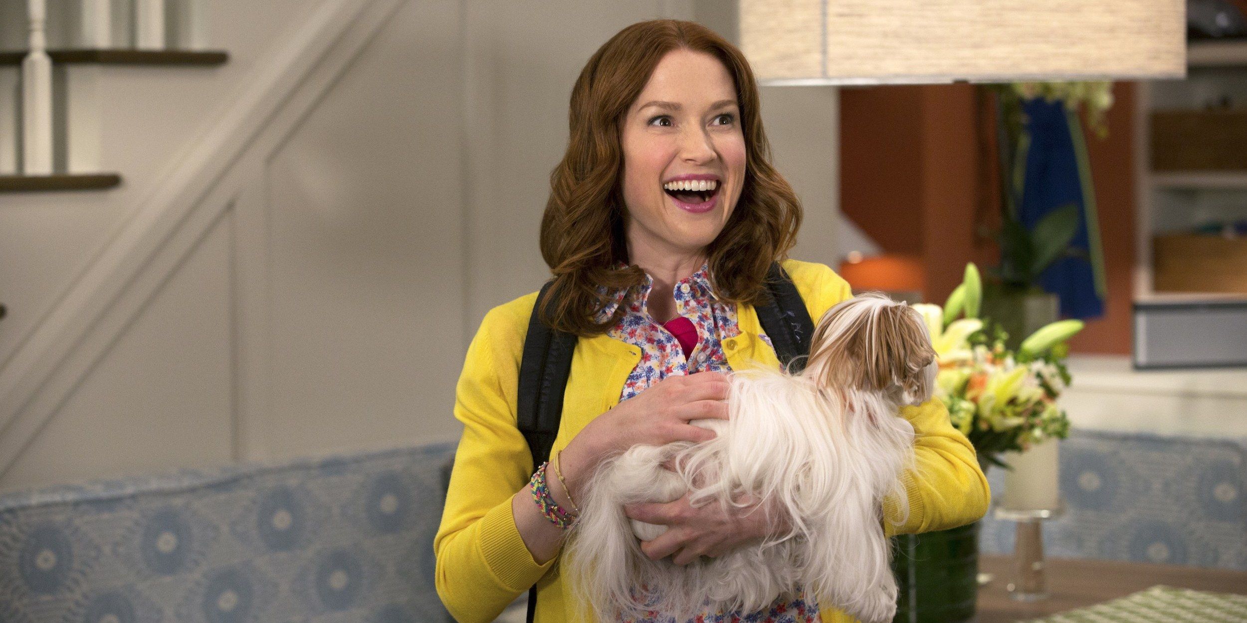 Kimmy holding a dog and smiling in Unbreakable Kimmy Schmidt
