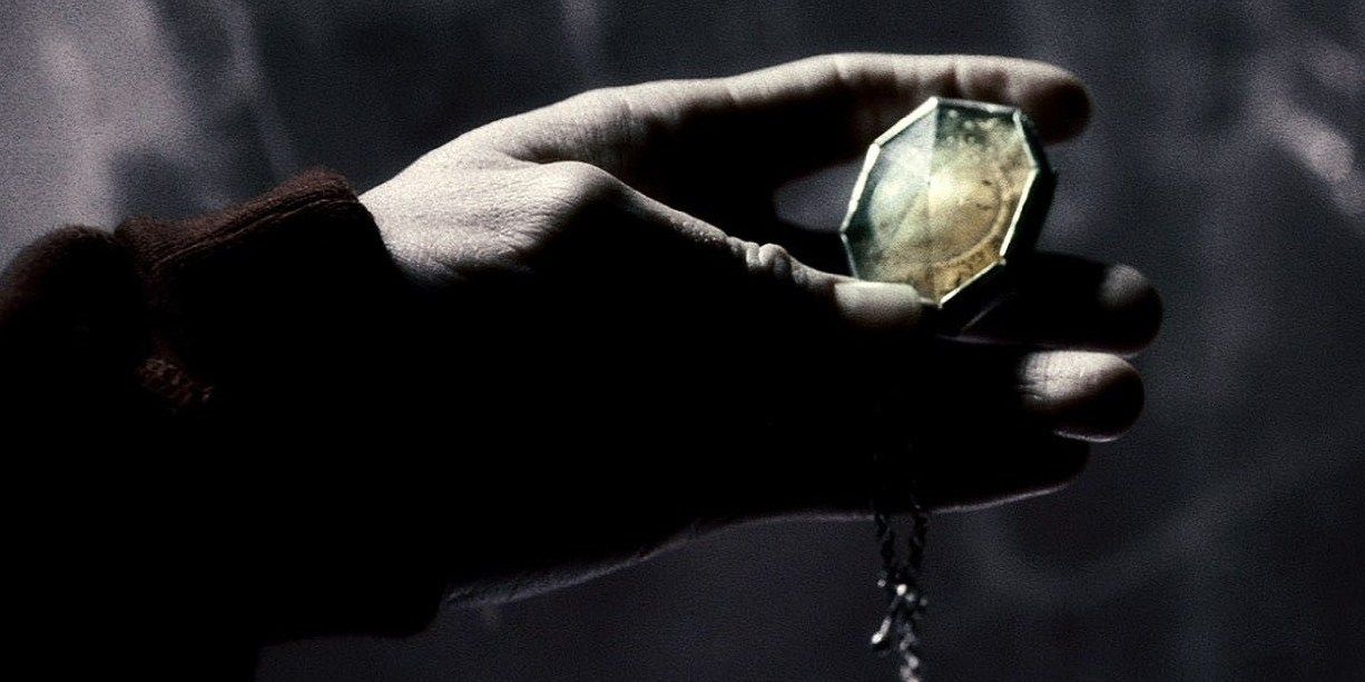 Harry mengeluarkan liontin Salazar Slytherin dari air mancur minum terkutuk di gua tepi pantai di Harry Potter & The Half-Blood Prince