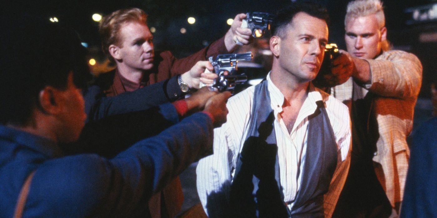Bruce Willis surrounded by men pointing guns at him in Hudson hawk