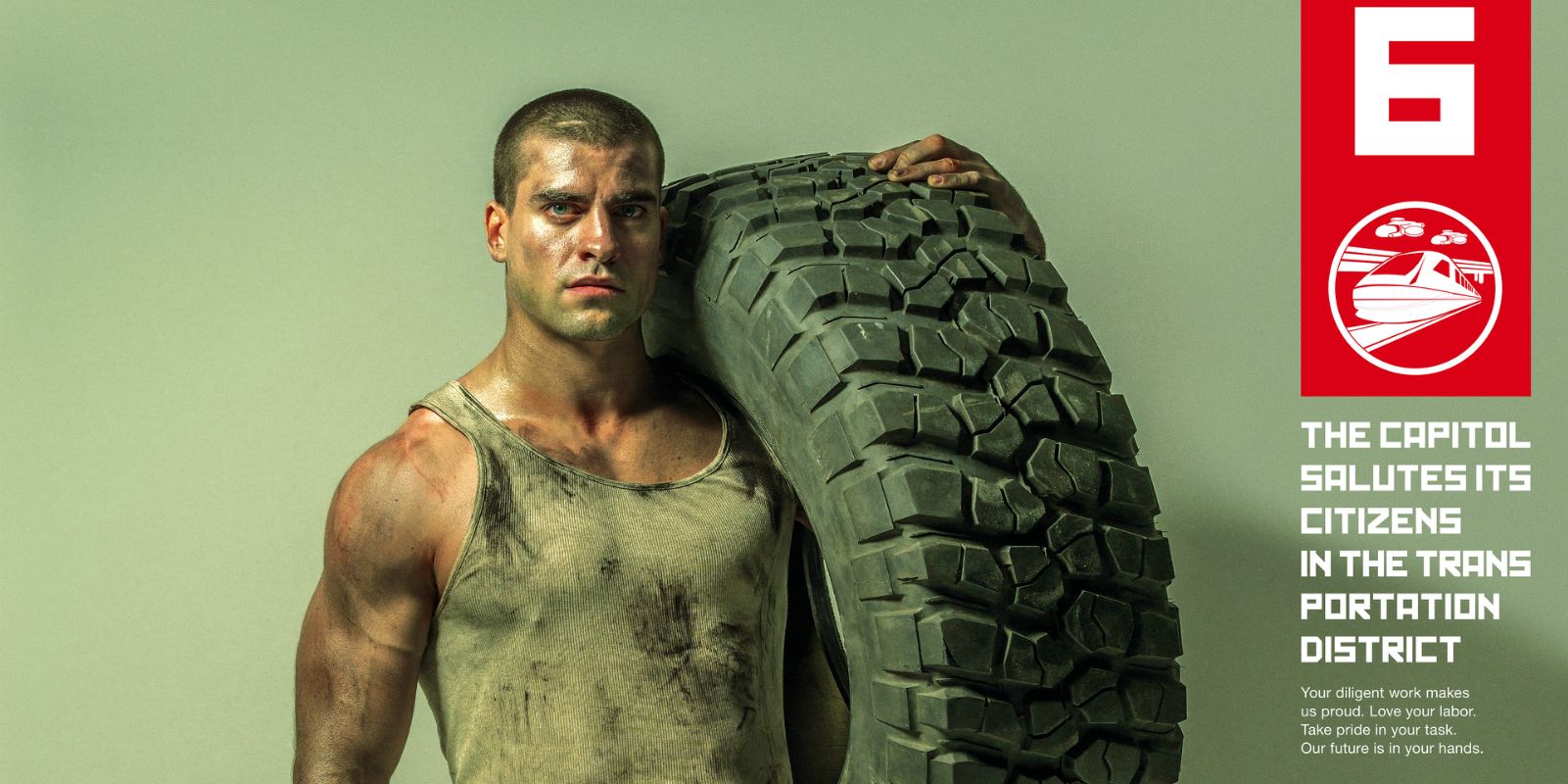 Hunger Games District 6 poster depicts a man carrying an oversized tire.