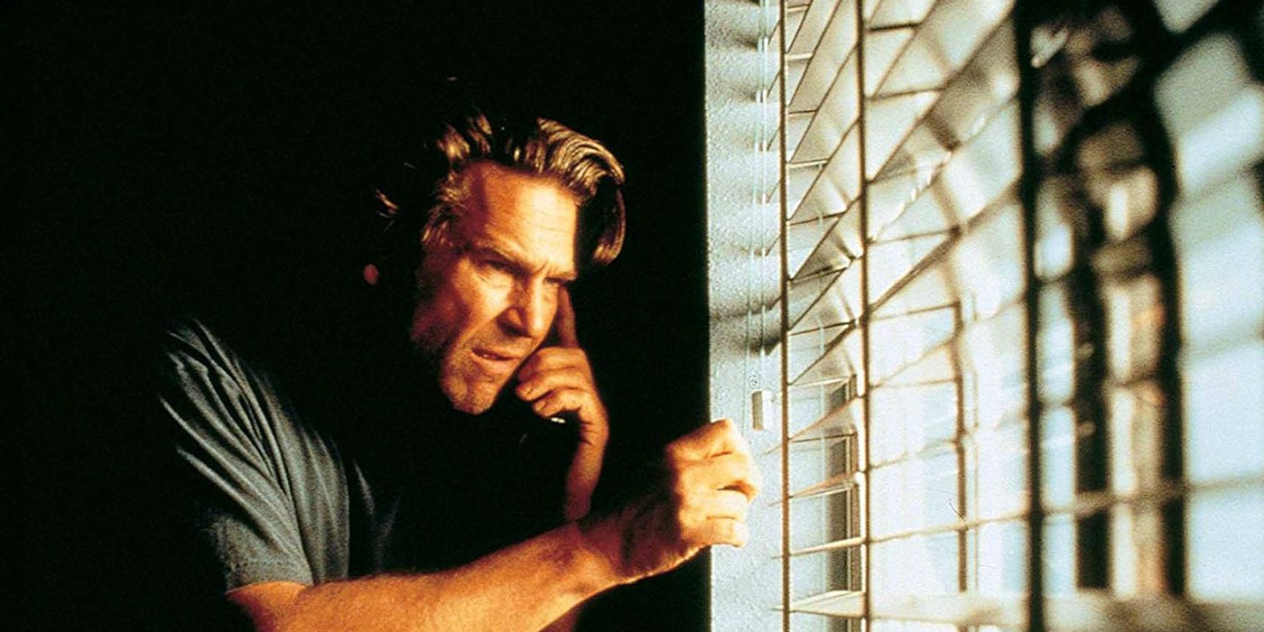 Michael Faraday (Jeff Bridges) olhando para fora das cortinas da janela