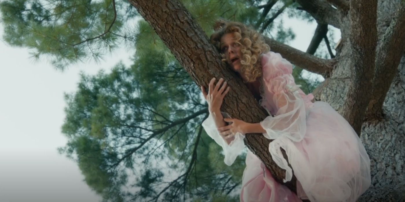 Juno Rinaldi as Frankie climbing a tree in a dress on Workin Moms