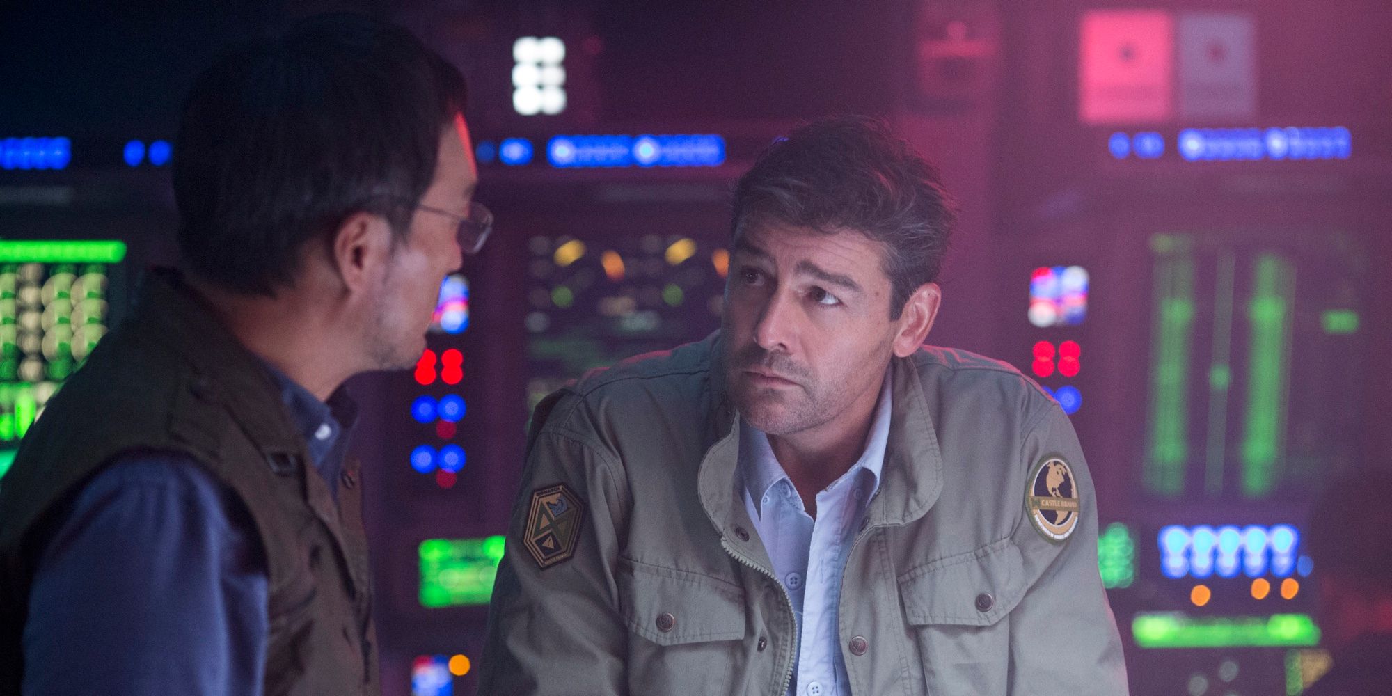Ken Watanabe and Kyle Chandler talks in a control room in Godzilla King of the Monsters