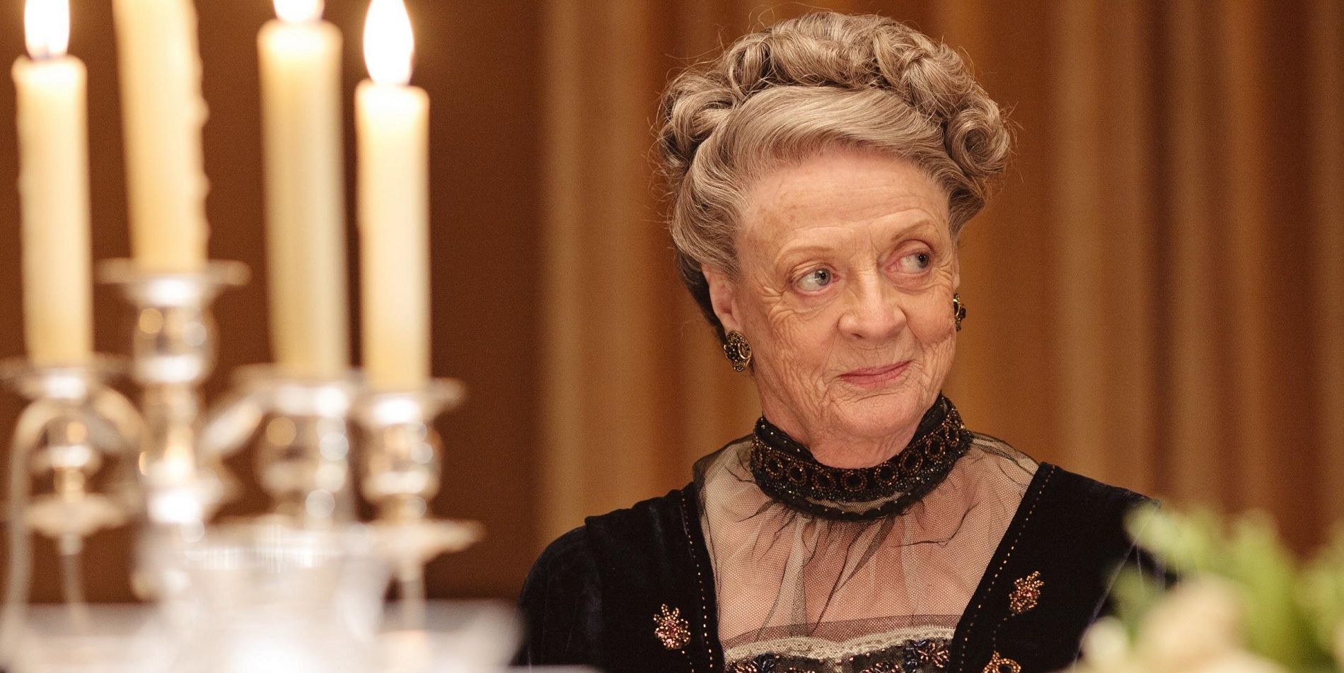 Dowager Countess Lady Violet Crawley smiling at the dinner table in Downton Abbey