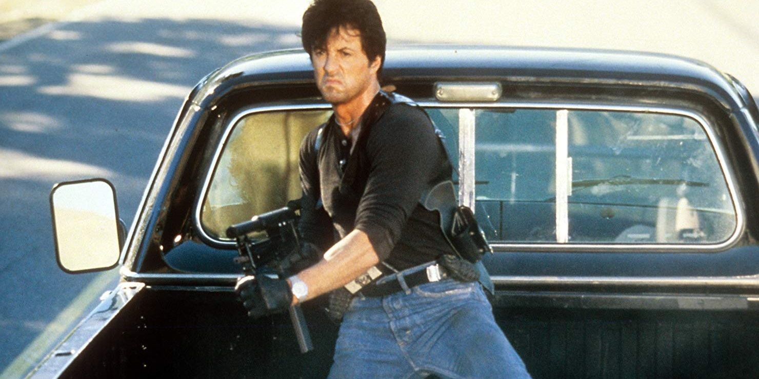 Sylvester Stallone with a gun in the back of a truck in Cobra