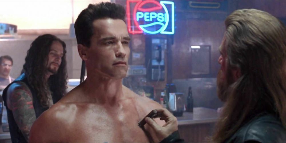 A biker putting out a cigar on Arnold Schwarzenneger's chest in a still from Terminator 2.