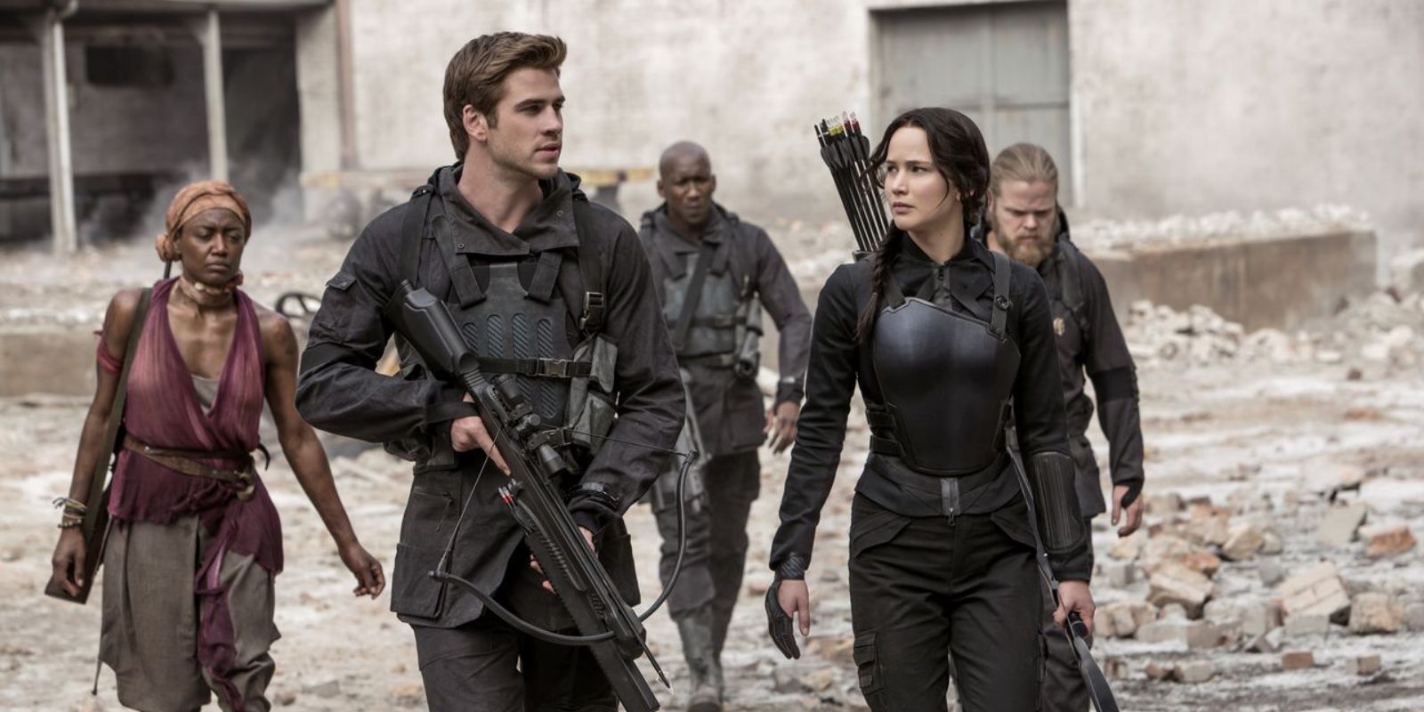 Gale y Katniss caminando con rebeldes en Los juegos del hambre Sinsajo Parte 1.
