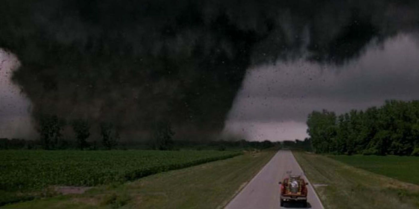 A car driving alongside a massive tornado in Twister.