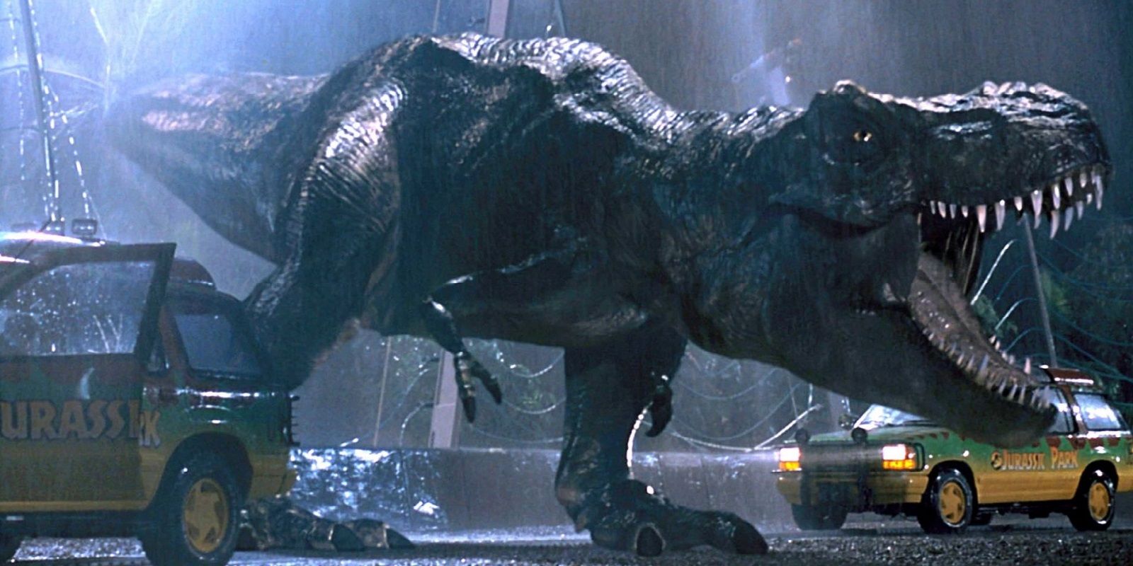O T-Rex rugindo pelos jipes enquanto atravessa a cerca no Jurassic Park