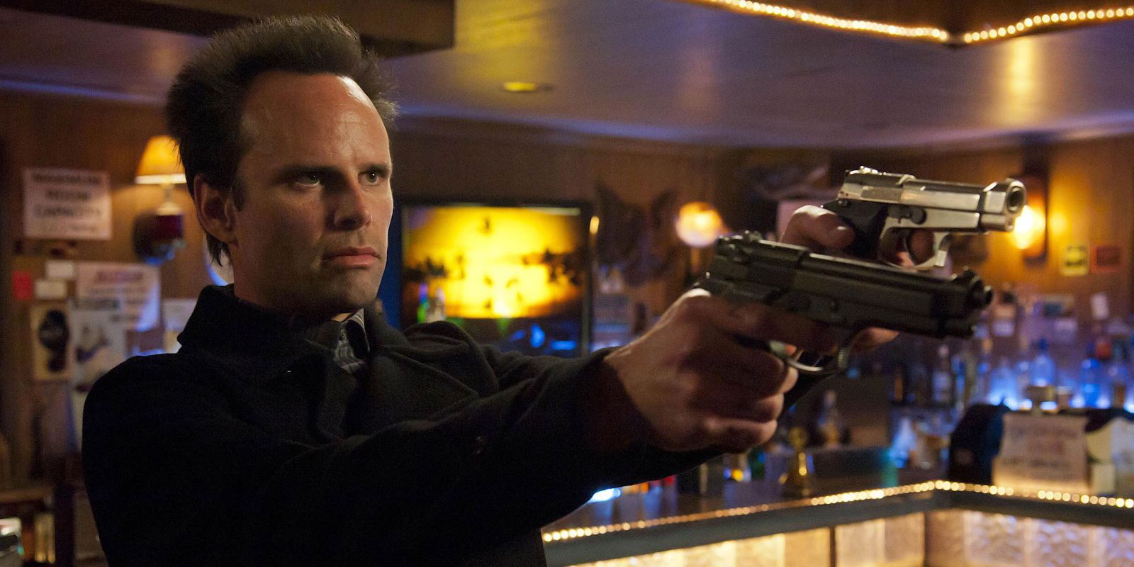 Boyd Crowder aiming a gun at a bar in Justified.