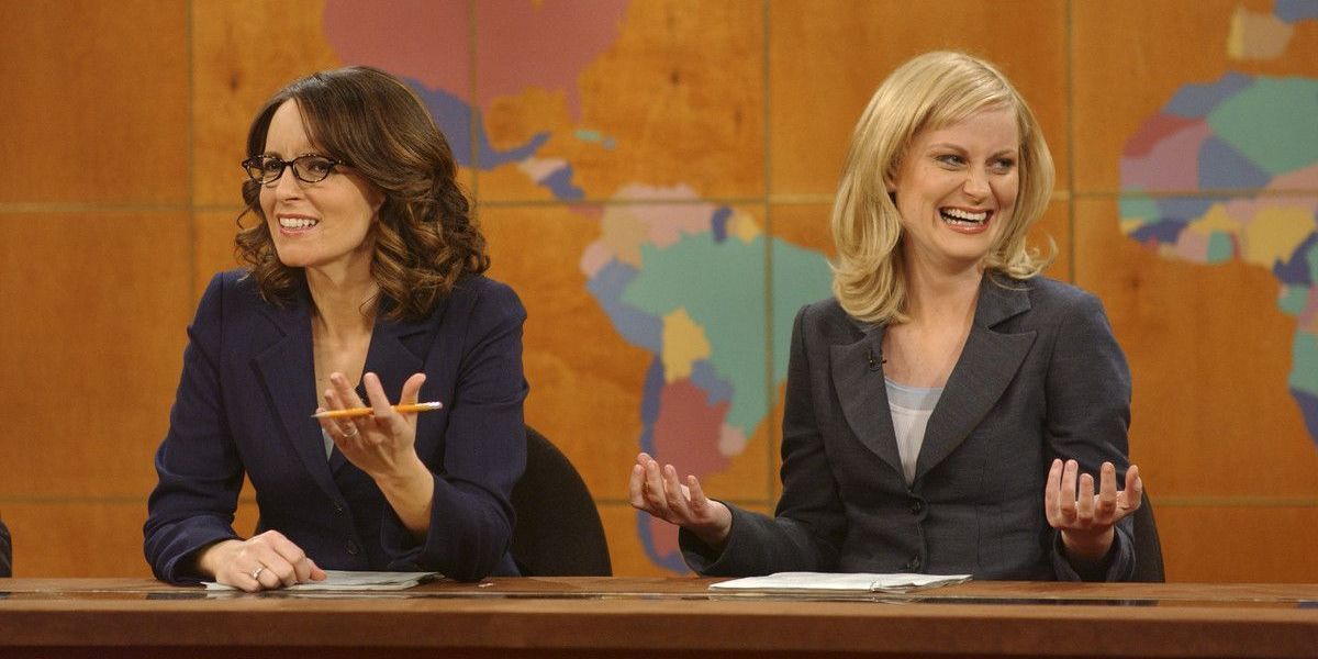 Amy Poehler laughs with Tina Fey during the Weekend Update segment.