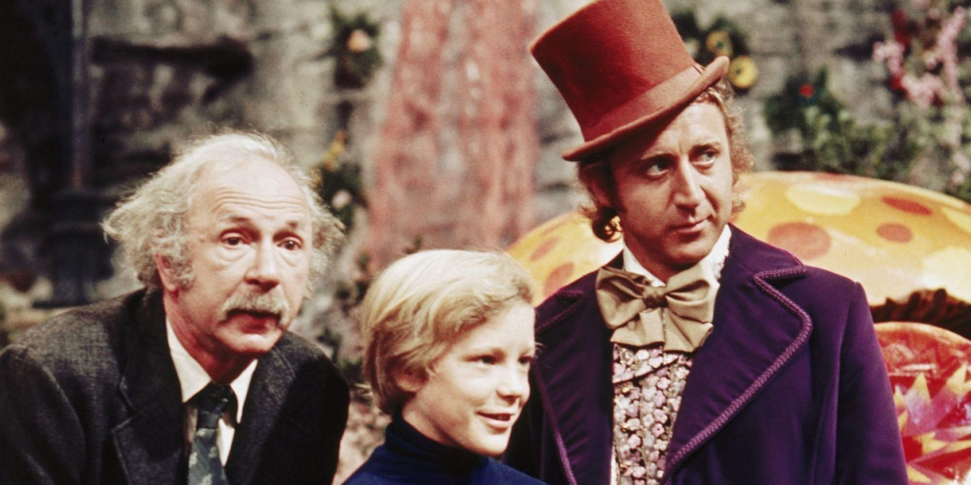 Grandpa Joe, Charlie and Willy Wonka are all looking at something