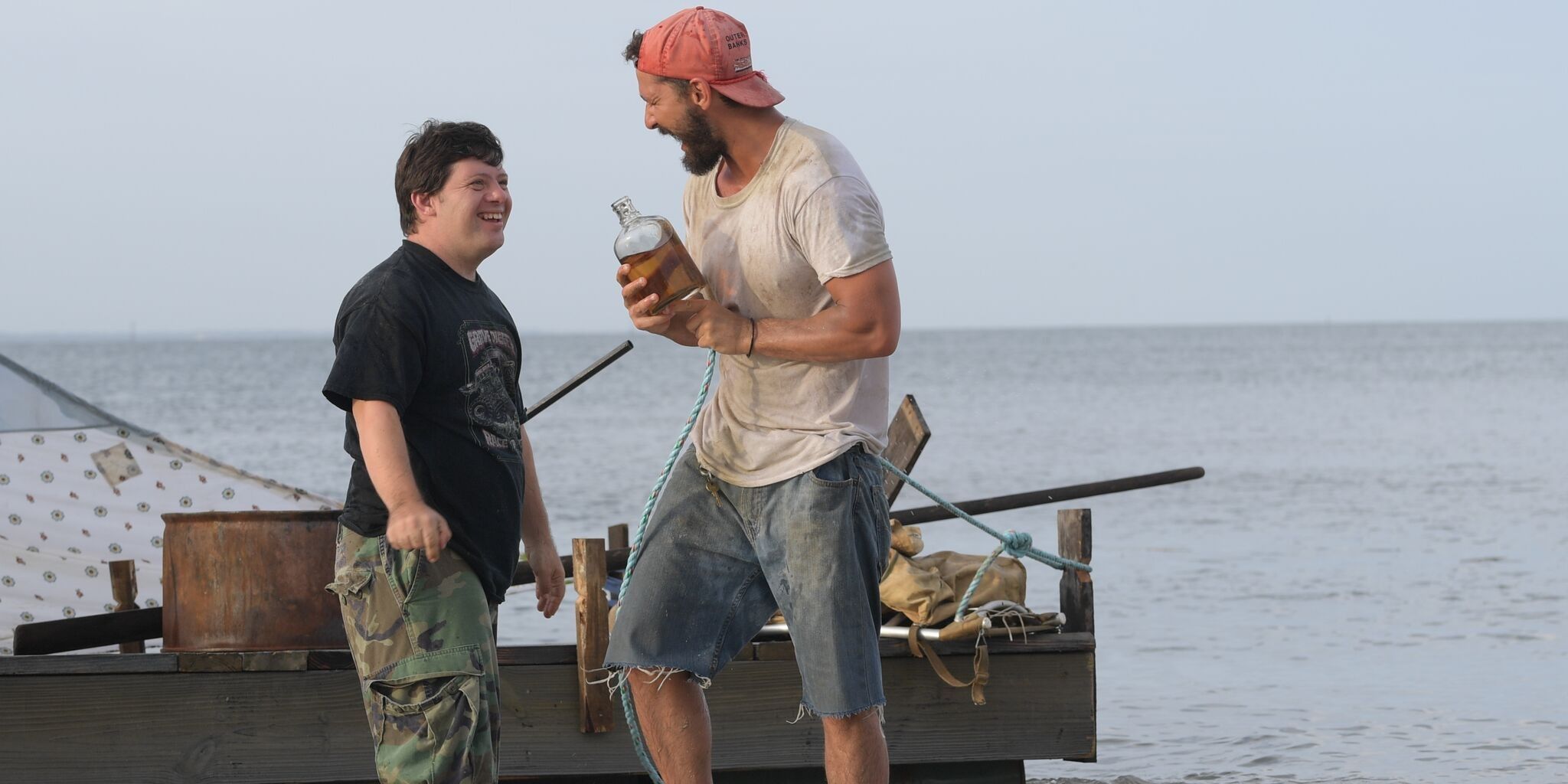 Zachary Gottsagen and Shia LaBeouf laughing on a boat in The Peanut Butter Falcon