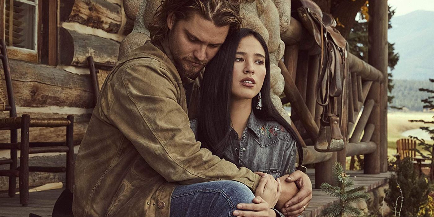 Luke Grimes and Kelsey Asbille hold each other in Yellowstone