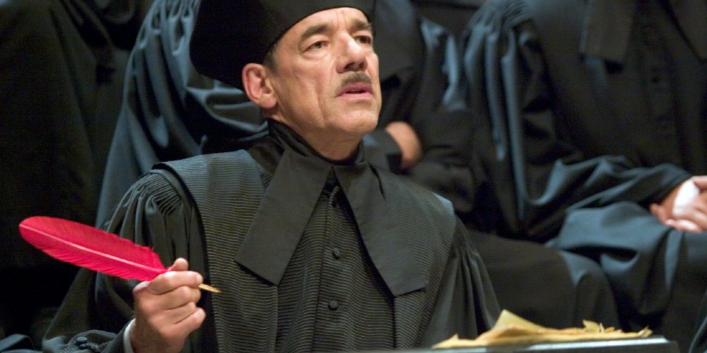Bartô Crouch segurando uma pena durante uma audiência em Harry Potter. 