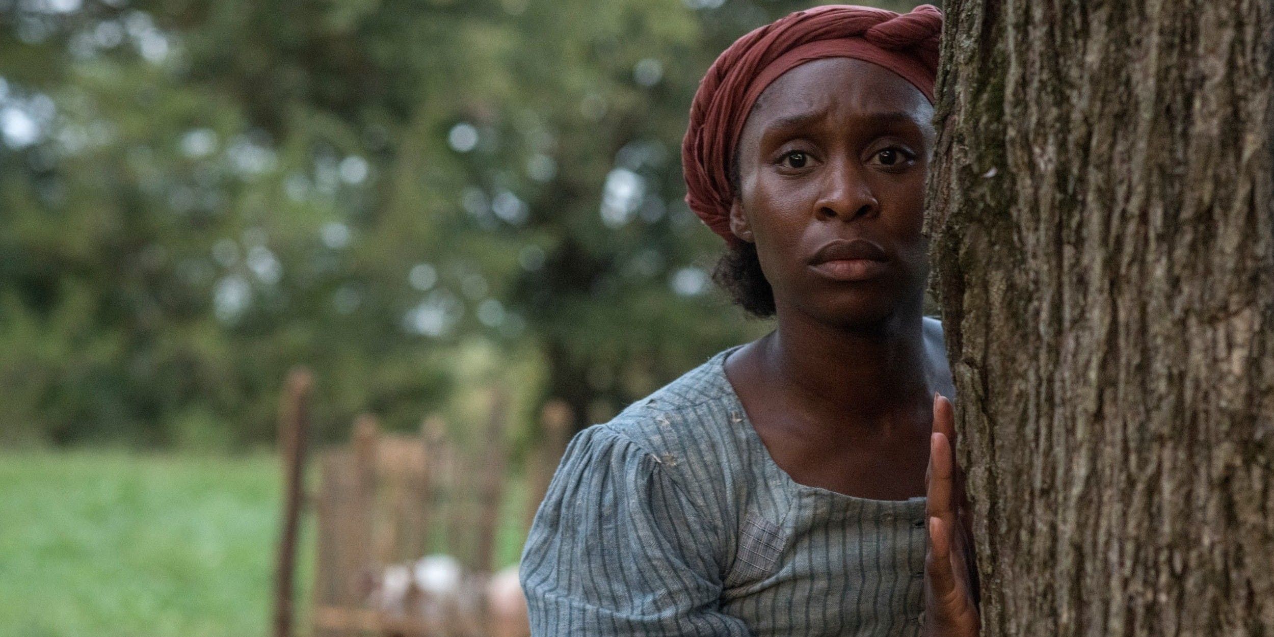 Harriet (Cynthia Erivo) looking around a tree in Harriet (2019)