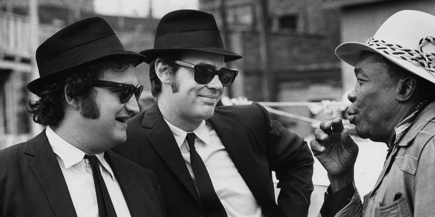 Dan Aykroyd e John Belushi como Jake e Elwood Blues em The Blues Brothers com John Lee Hooker