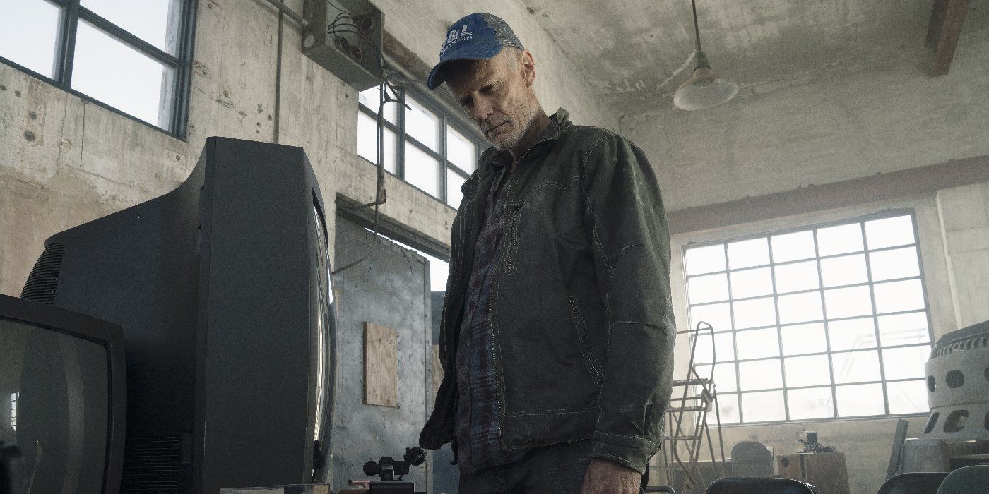 Logan from Fear the Walking Dead looking down with a baseball hat.
