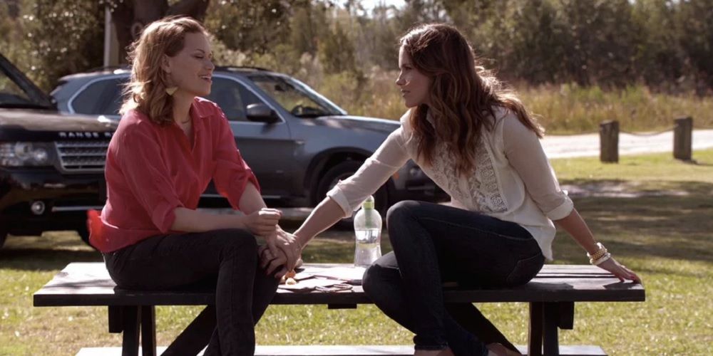 Haley James Scott and Brooke Davis sit on a picnic table in One Tree Hill