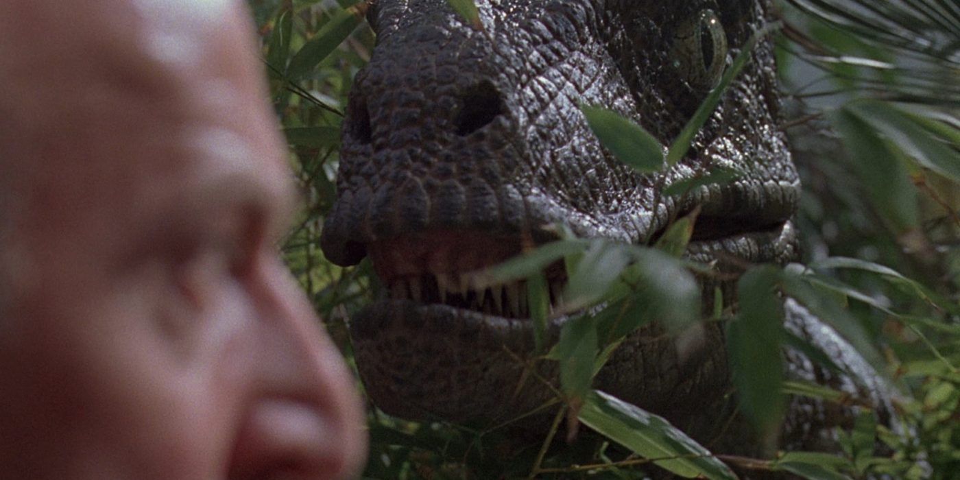 The velociraptor appears out of the trees to surprise Muldoon in Jurassic Park