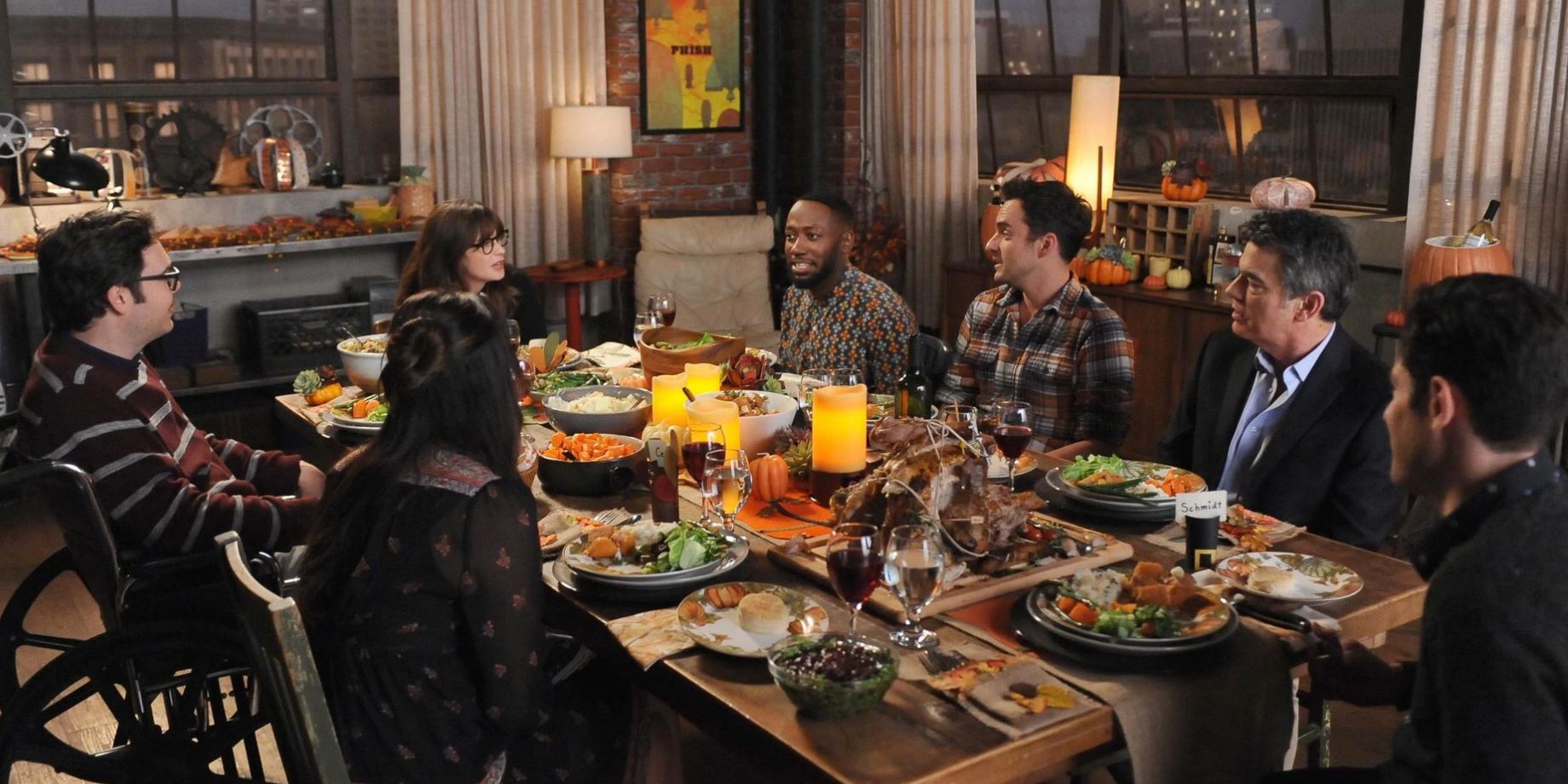The residents of apartment 4D sit around the table with Robbie and Schmidt's father in New Girl's Last Thanksgiving