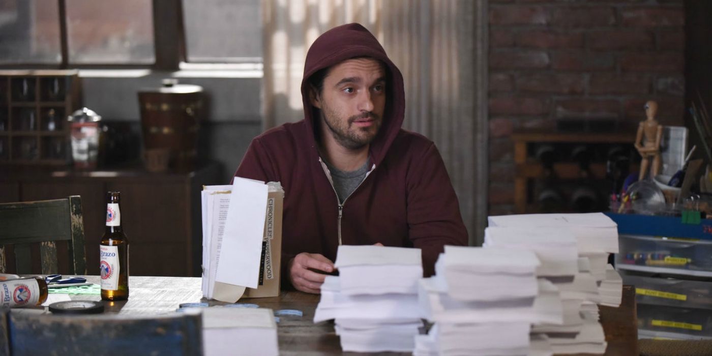 Nick Miller in a hoodie and binding copies of his books in New Girl