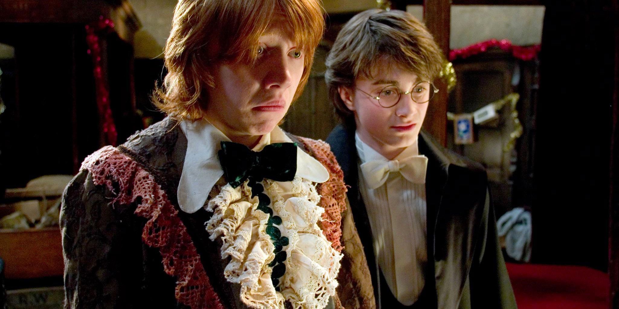 Rob and Harry look in the mirror at Ron's robes at the Yule Ball