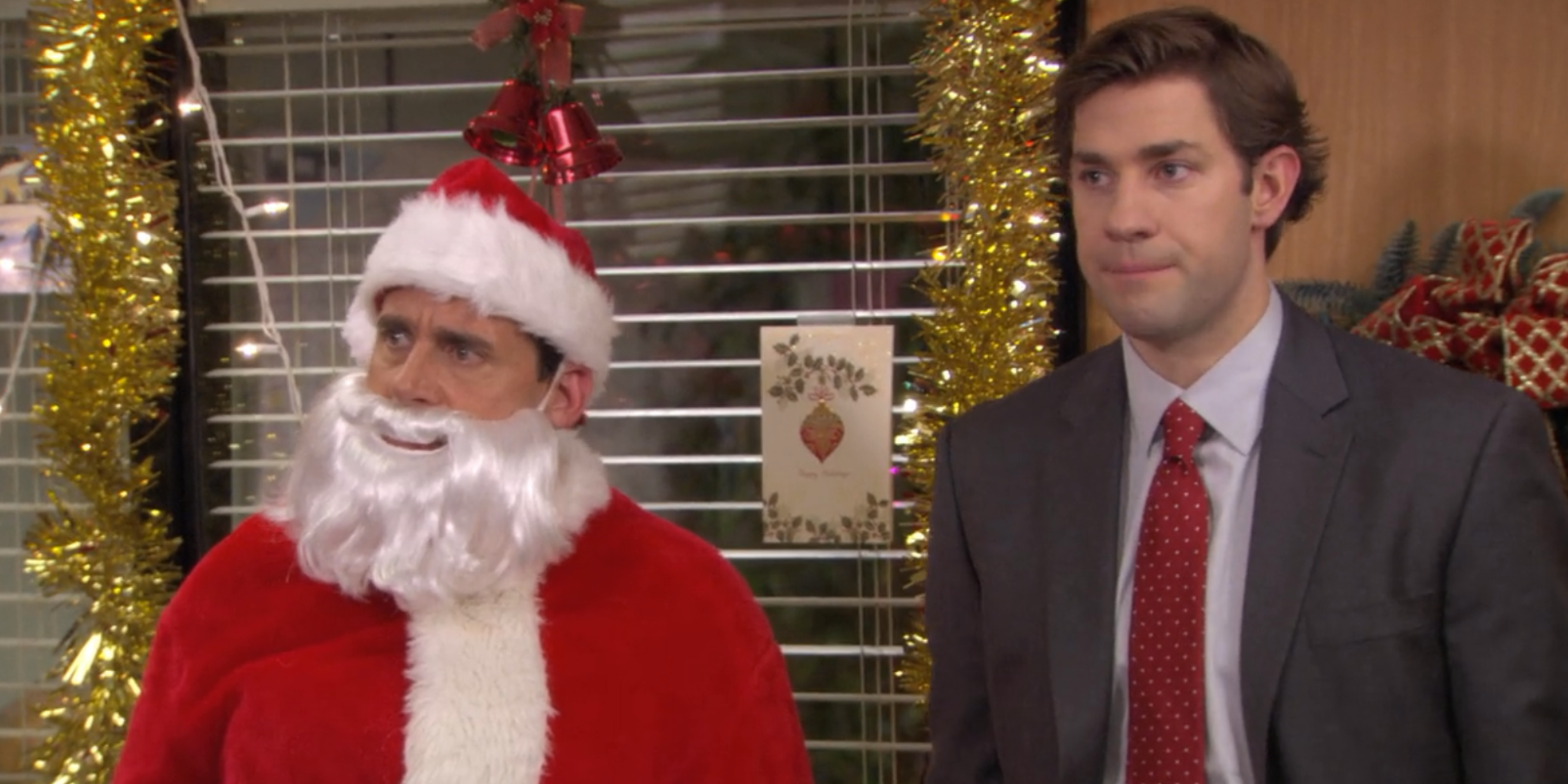 Michael is dressed as Santa while Jim stands next to him disapprovingly on The Office