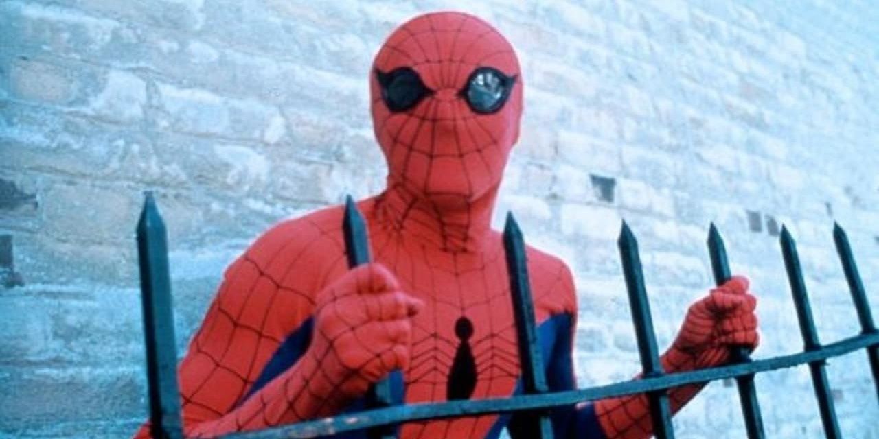 Peter Parker holds onto a fence in the 1977 film Spider-Man
