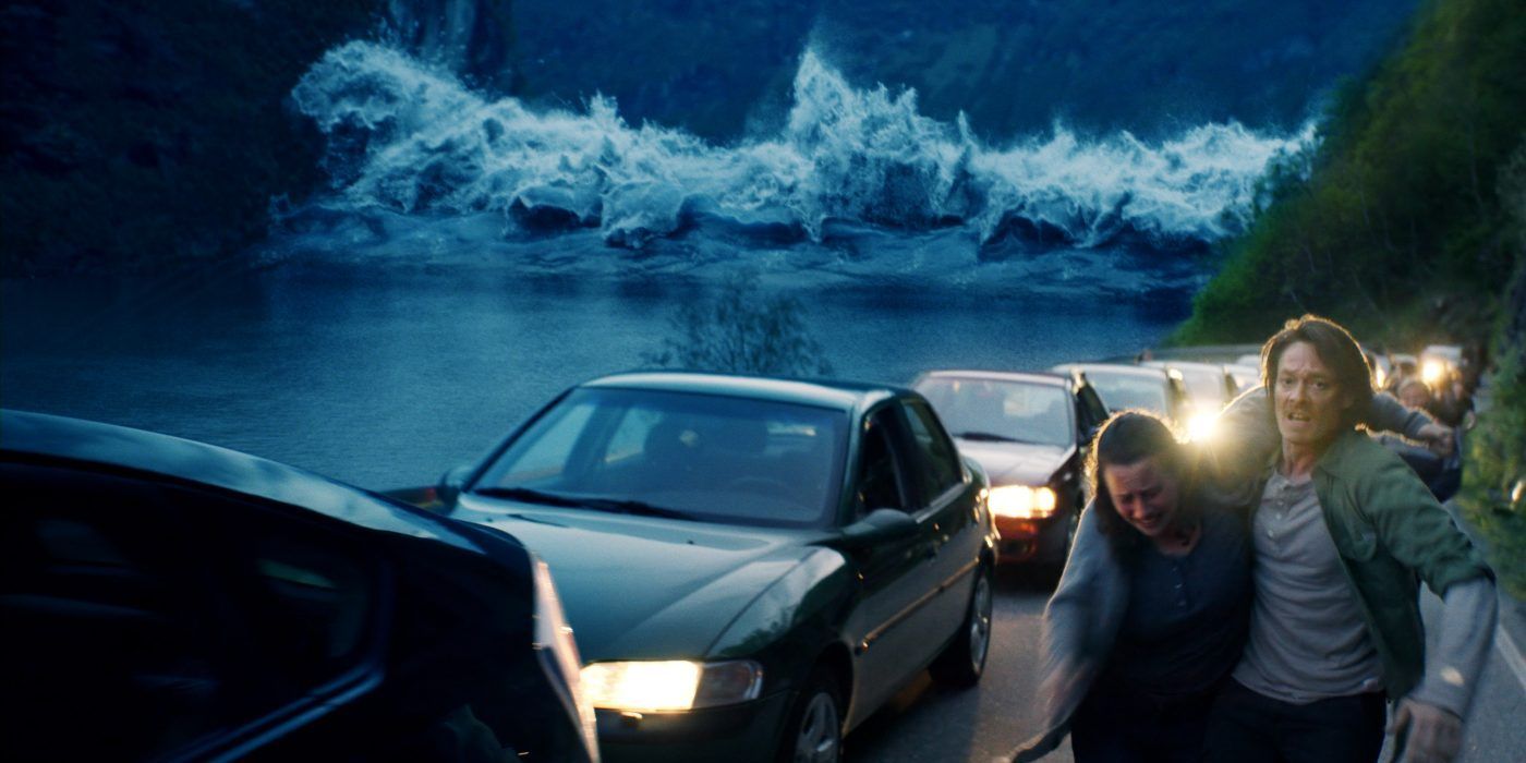 Kristoffer Joner como Kristian Eikjord ajudando Silje Breivik como Anna a se afastar do tsunami em The Wave