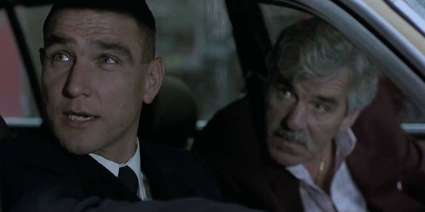 Vinnie Jones as Tony and Dennis Farina as Avi looking out a car window in Snatch