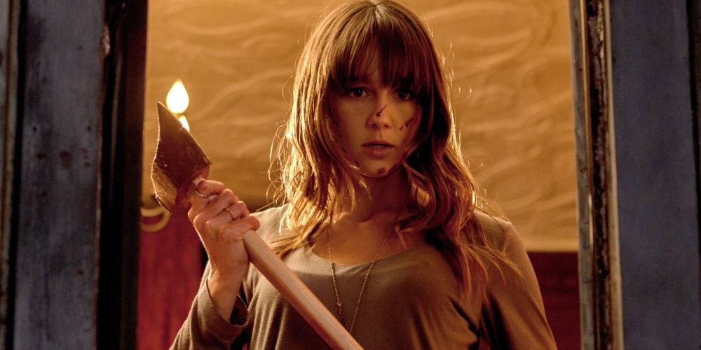 A young woman holding an axe in You're Next.