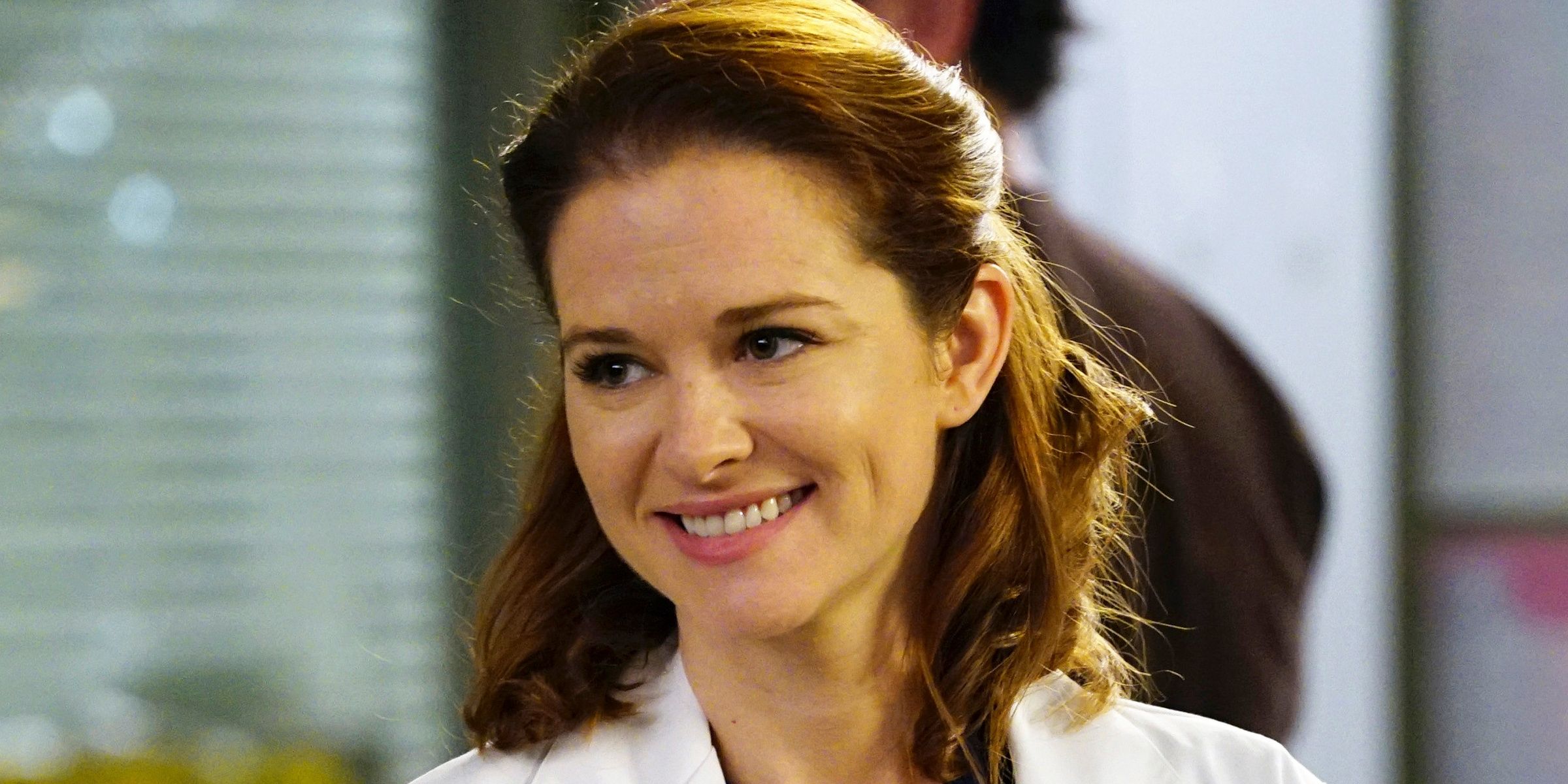 Sarah Drew como Kepner sorrindo no hospital em Grey's Anatomy