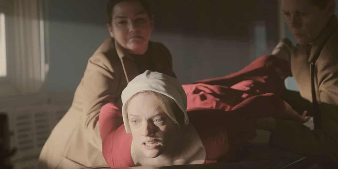 June from The Handmaid's Tale being held down and whipped by aunts.