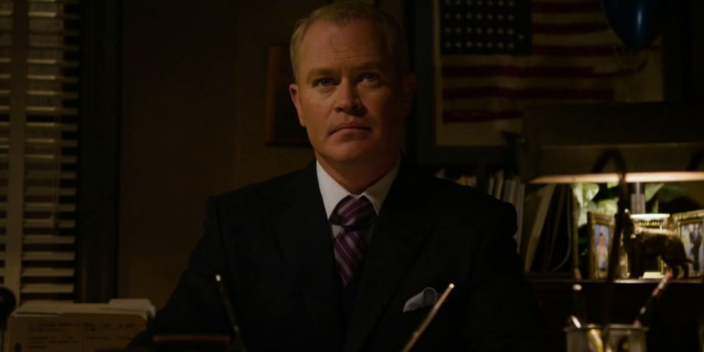 Robert Quarles sitting at a desk in Justified