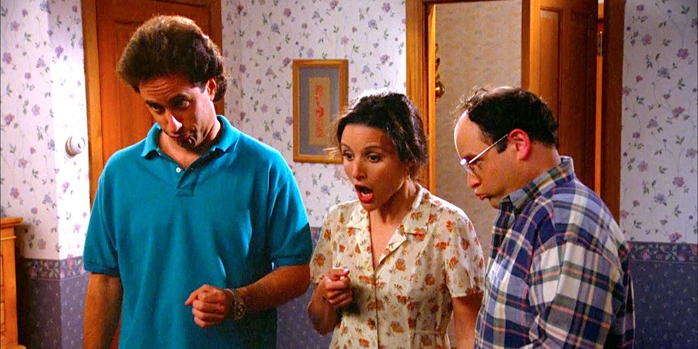 George, Elaine and Jerry looking at the baby in The Hamptons episode of Seinfeld.