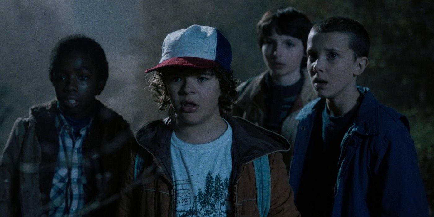 Lucas, Dustin, Mike e Eleven olham para algo assustado