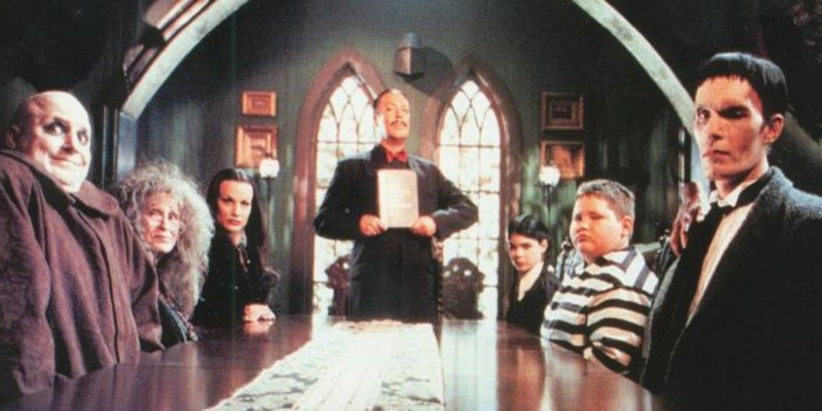 An image of the Addams family standing around a table together