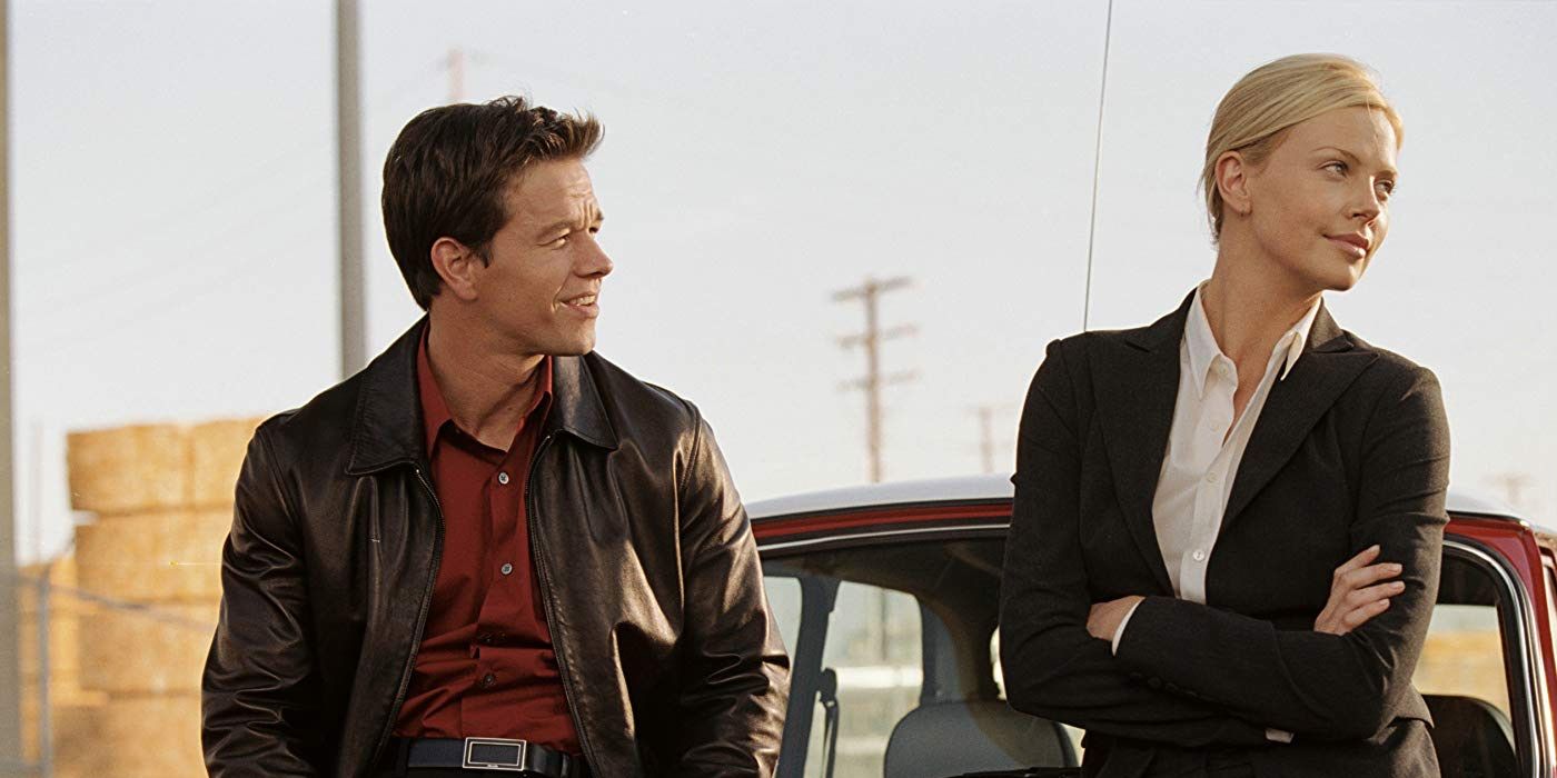 Mark Wahlberg and Charlize Theron leaning against a Mini Cooper in The Italian Job