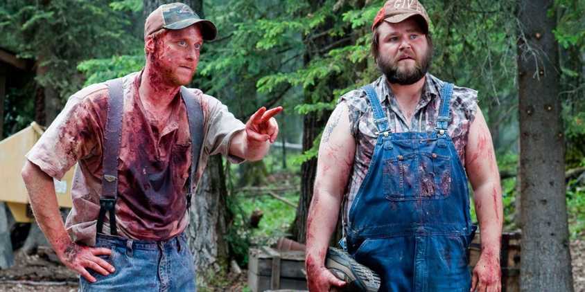 Tucker and Dale covered in blood in the wood in Tucker and Dale vs. Evil.