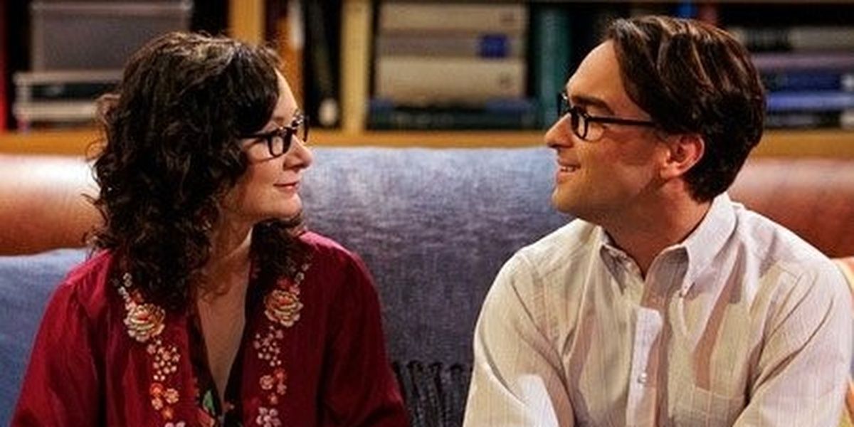 Leslie and Leonard talking on the couch in The Big Bang Theory