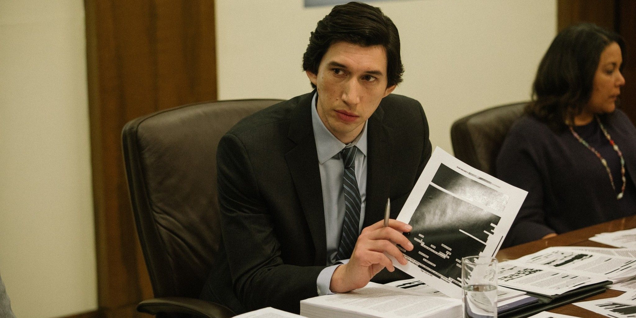 Adam Driver holding a censored page from a government document in a still from The Report