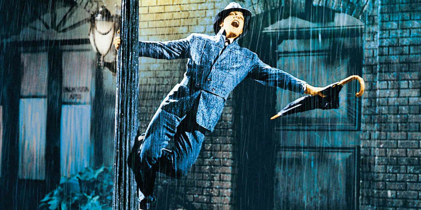 Don Lockwood swinging on a lightpost under the rain in Singin' In The Rain 1952