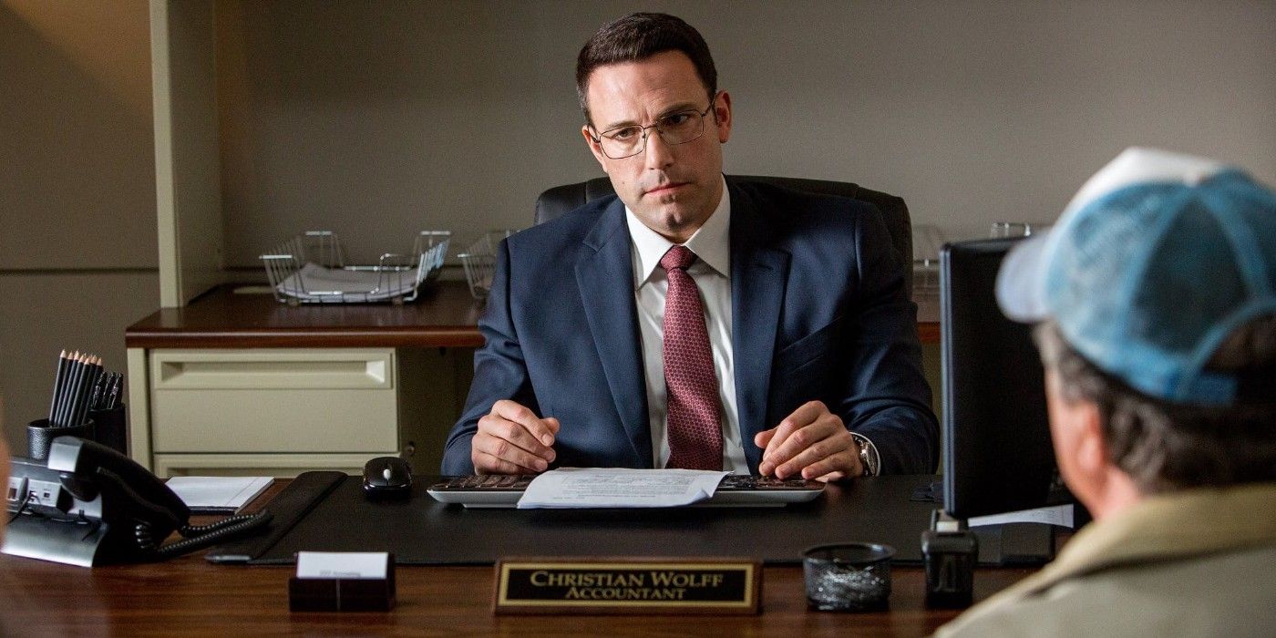 Ben Affleck as Christian Wolff sitting at a desk in The Accountant