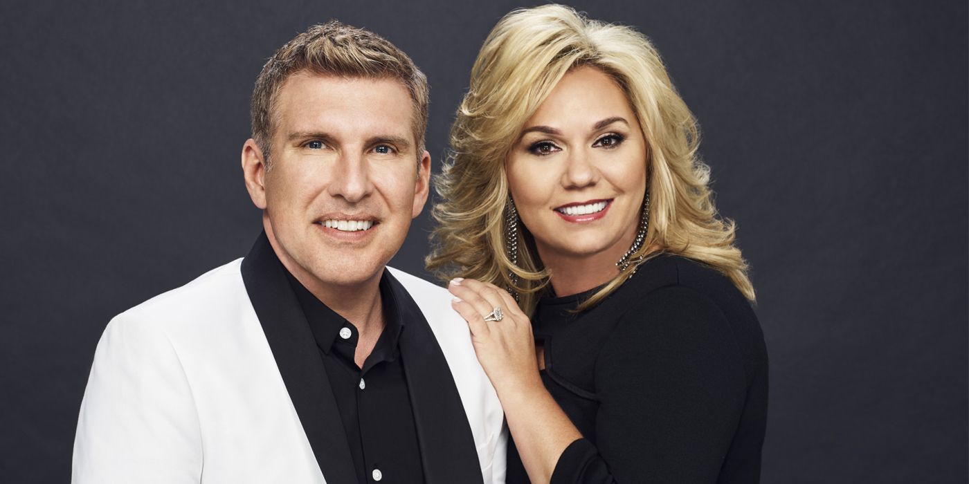 Chrisley Sabe Tudo Todd e Julie Chrisley em trajes formais posando com a mão de Julie no ombro de Todd sorrindo 