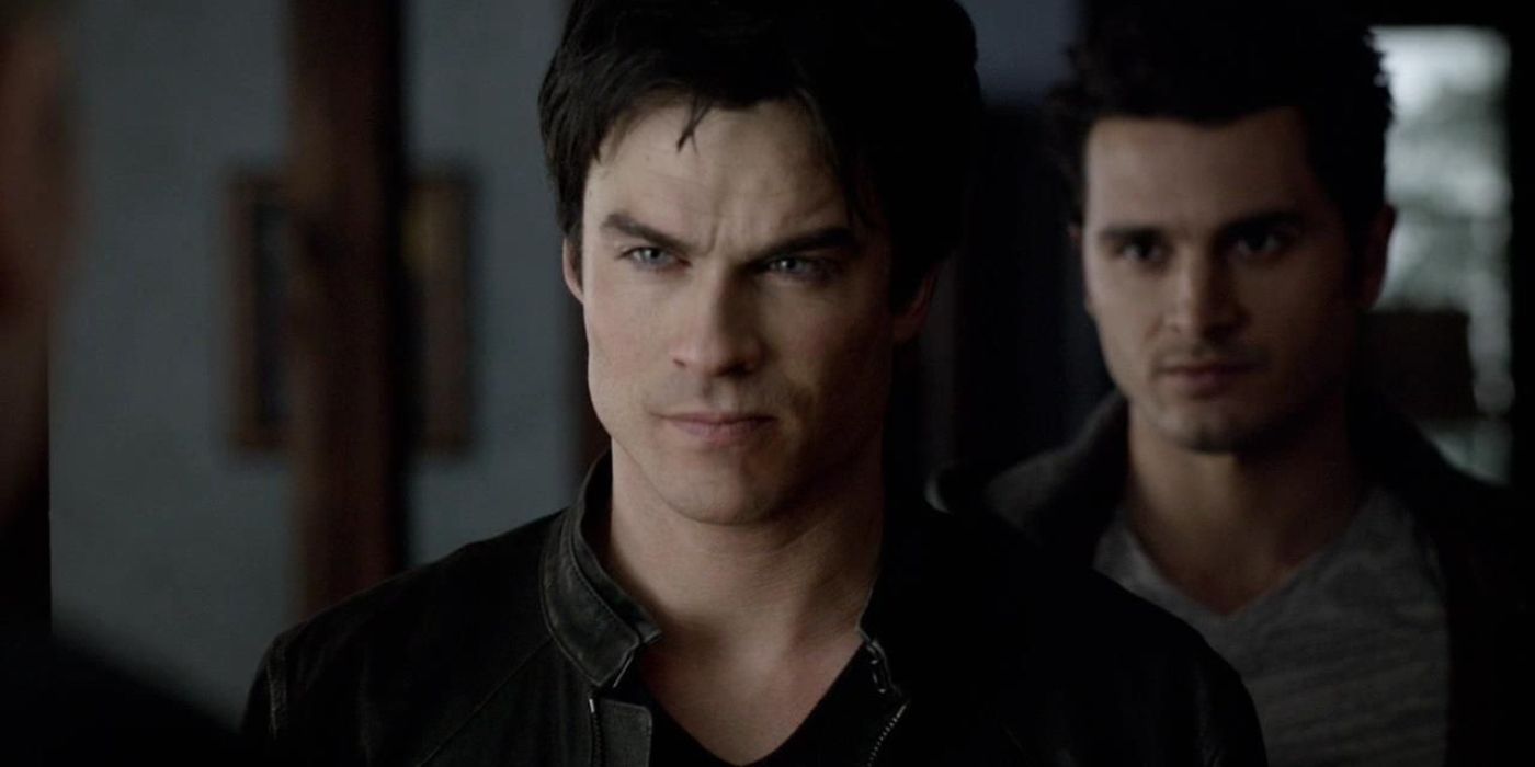 An image of Damon looking angry with Enzo behind him on The Vampire Diaries