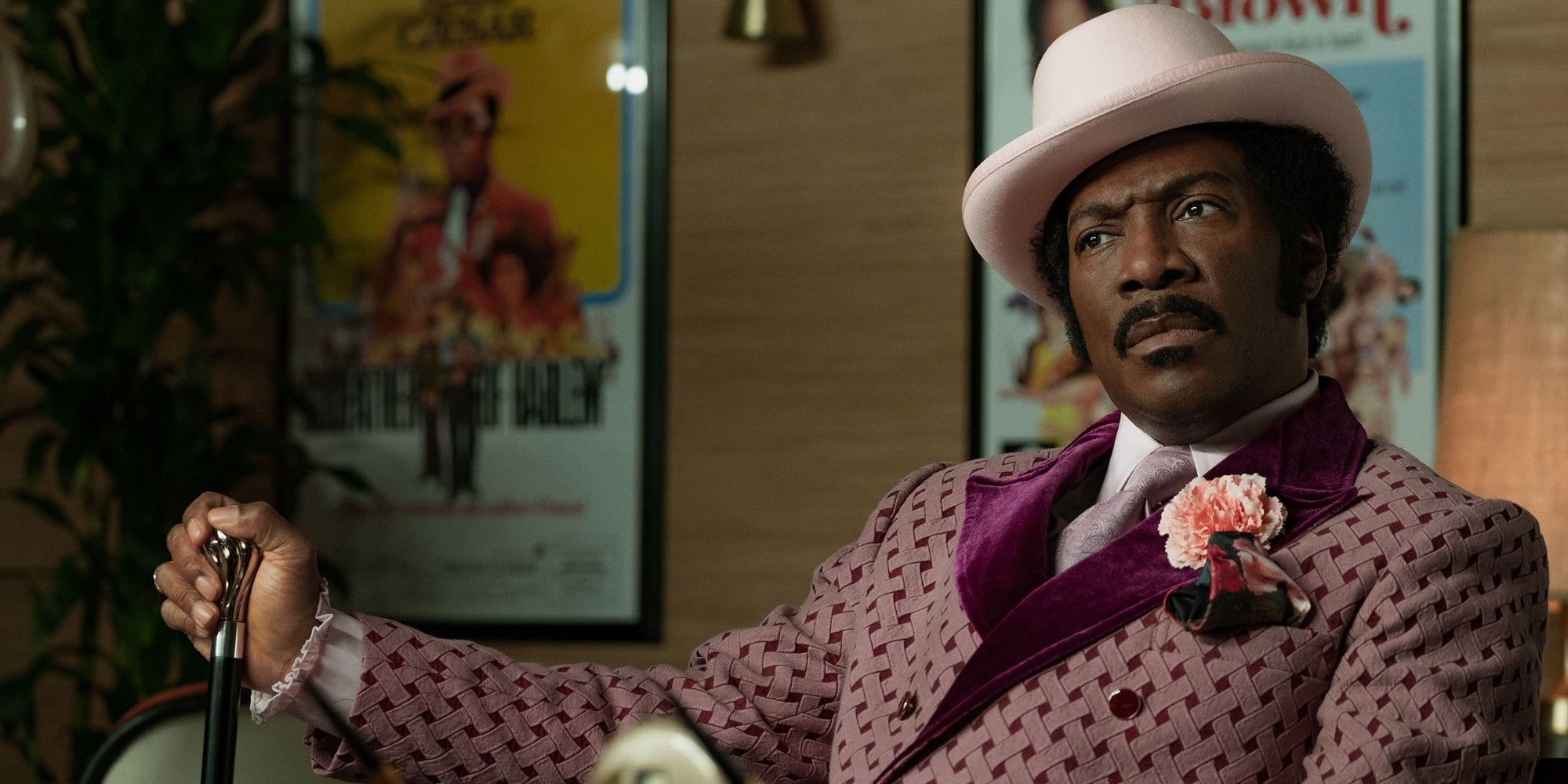Eddie Murphy as Rudy Ray Moore, sitting and looking confused in Dolemite Is My Name