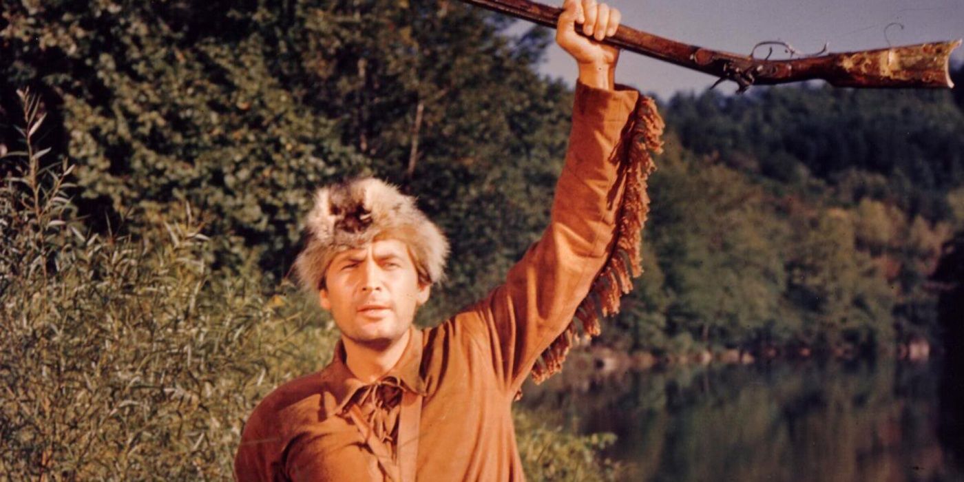 Davy Crockett wearing his coonskin cap and holding up a rifle in Disney's The Ballad Of Davy Crocket.